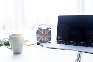 Çalar saat, sabah güneş ışığında beyaz masanın üzerine kapanır..