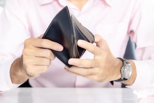 Men looking at money in a purse,business person holding an empty wallet (no money)