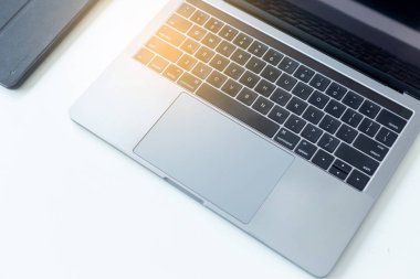 Masaüstü bilgisayar ofisi olan çalışma alanını kapat, güneş ışığı olan beyaz masadaki laptopu kapat