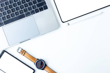 Masaüstü bilgisayar ofisi, dizüstü bilgisayarı ve tableti güneş ışığıyla beyaz masadaki en üst görünüm çalışma alanı