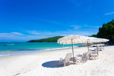 Mavi gökyüzü ve bulutlarla mavi deniz, tropikal plaj arka planı plaj sandalyeleri ve güzel deniz manzaralı yaz manzarası.