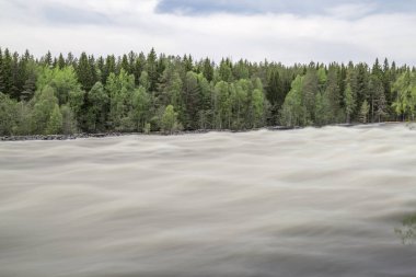 Vindeln, İsveç'te Renforsen, ivinti parçalı bulutlu bir gökyüzü ile.