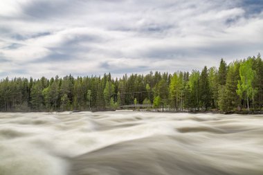 Vindeln, İsveç'te Renforsen, ivinti parçalı bulutlu bir gökyüzü ile.