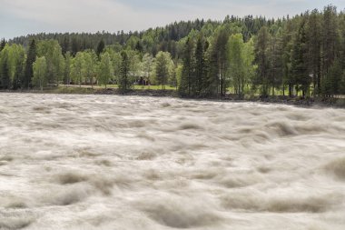 Vindeln, İsveç parçalı bulutlu bir gökyüzü ve kırmızı evleri ile Renforsen, Rapids.