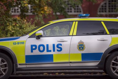 İsveç polis arabası park sonbahar yaprakları ile.