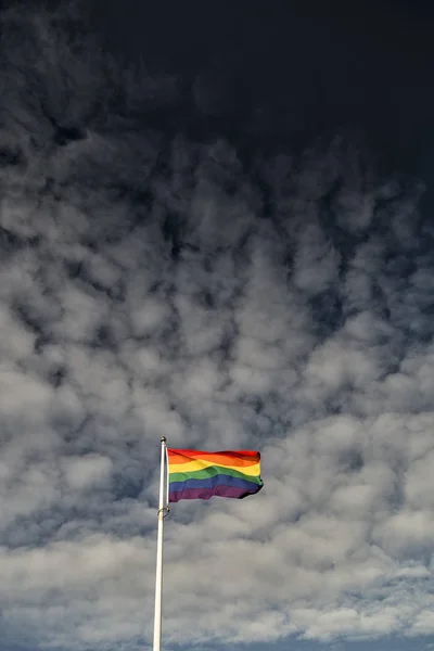 彩虹旗在风中挥舞着一片多云的天空 — 图库照片