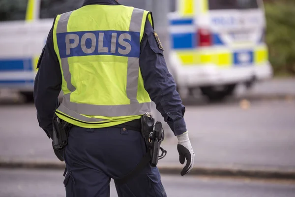Yansıtıcı yelek ve silah ile İsveç polis memuru