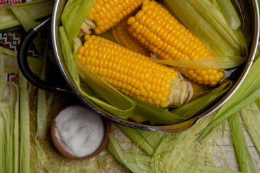 Tuz ile tatlı Mısır kaynatın. tatlı mısır ahşap masa üzerinde tencerede pişirilir