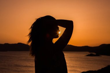 mutlu kadın ve günbatımı silüeti.