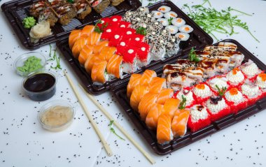 Japon yemekleri plastik kutuda yuvarlanıyor. Sushi plastik bir paketin içinde, beyaz bir arka planda izole edilmiş. Paket veya suşi servisi için suşi..