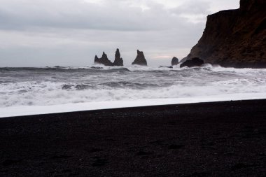 Görüntü siyah kum plaj yakınındaki South Coast İzlanda, Vik. Beyaz Köpük Güney İzlanda bir siyah lav plajda. Konumlar ve İzlanda doğası.