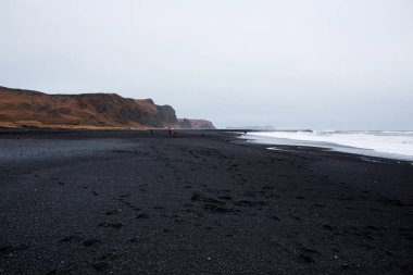 Görüntü siyah kum plaj yakınındaki South Coast İzlanda, Vik. Beyaz Köpük Güney İzlanda bir siyah lav plajda. Konumlar ve İzlanda doğası.