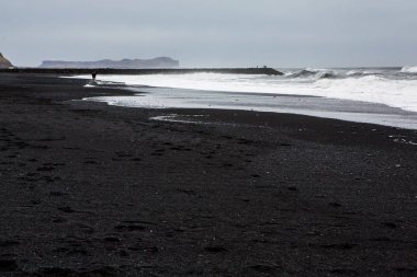 Görüntü siyah kum plaj yakınındaki South Coast İzlanda, Vik. Beyaz Köpük Güney İzlanda bir siyah lav plajda. Konumlar ve İzlanda doğası.