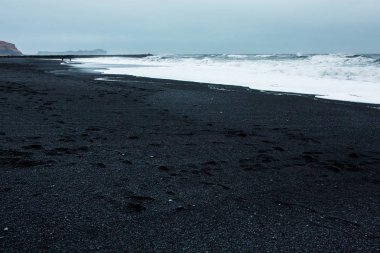 Görüntü siyah kum plaj yakınındaki South Coast İzlanda, Vik. Beyaz Köpük Güney İzlanda bir siyah lav plajda. Konumlar ve İzlanda doğası.