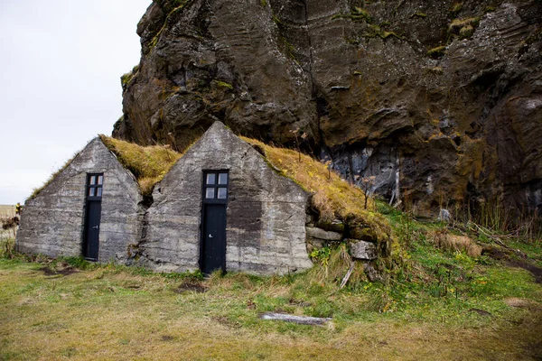 전형적인 아이슬란드 잔디로 있습니다 아이슬란드 잔디와 백그라운드에서 절벽으로 하우스 — 스톡 사진