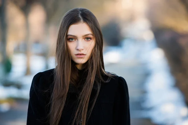 Portrait of a beautiful girl with flying hair in the wind. Young sad woman. Portrait of lonely woman