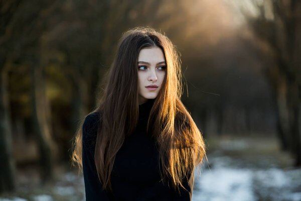 Portrait of a beautiful girl with flying hair in the wind. Young sad woman. Portrait of lonely woman