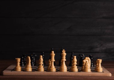 Satranç taşları ile satranç masası. Satranç koyu arka plan üzerinde. İş başarı kavramı. Strateji. Şah-mat. 