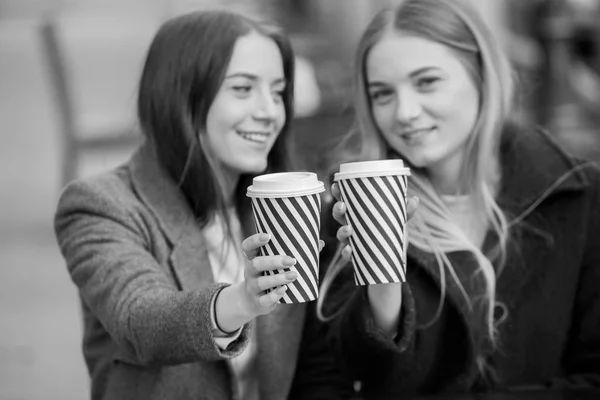 Two friends relaxing and drinking coffee .Coffee break.Coffee to goStylish hipster girl drinking coffee in street.