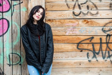 Siyah deri ceketli dalgalı saçlı güzel kız. Sevimli genç iş kadını açık portresi