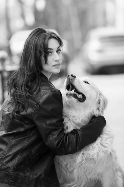 Beautiful woman playing with a dog. Portrait of a beautiful girl with her beautiful dog walking outdoors