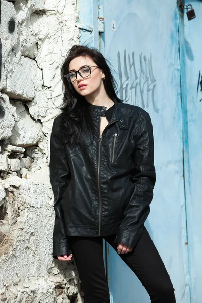 fashion model in black leather jacket posing outdoor. outdoor portrait of young european beautiful stylish girl