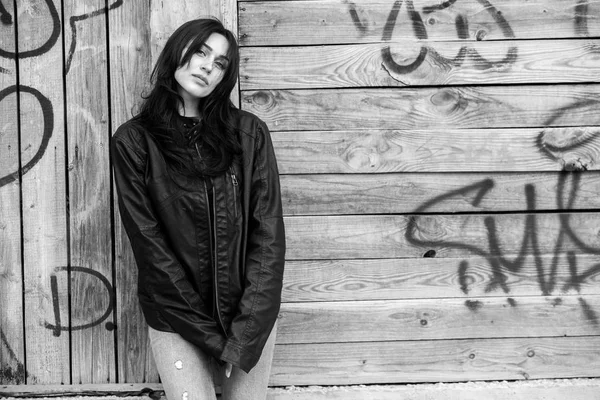 Beautiful girl with wavy hair in black leather jacket. Portrait of cute young business woman outdoor