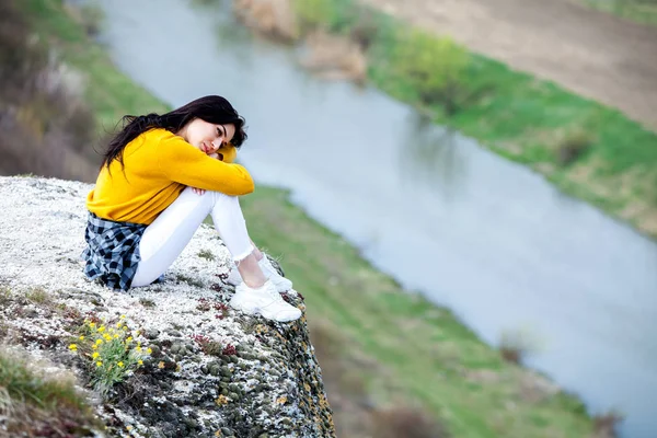 Genç bir gezgin kız vadinin tepesinde oturur. Genç kız vahşi hayat, seyahat, özgürlük seviyorum. Seyahat turist mutlu kadın. Seyahat ve Wanderlust kavramı