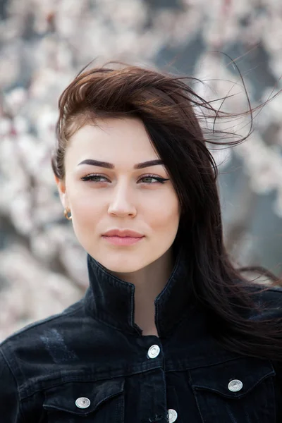 Beauty fashion portrait of young beautiful brunette girl with long black hair and green eyes. Beauty portrait of female face with natural skin.