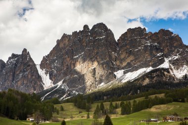İlkbaharda güzel güneşli bir günde çiçek açan taze yeşil çayırları ile Alpler'de güzel dağ manzarası. İtalya'da Dolomiti montains. Avrupa'da ilkbaharda peyzaj. 