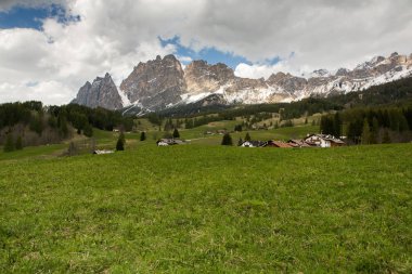 İlkbaharda güzel güneşli bir günde çiçek açan taze yeşil çayırları ile Alpler'de güzel dağ manzarası. İtalya'da Dolomiti montains. Avrupa'da ilkbaharda peyzaj. 