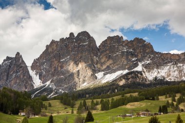 İlkbaharda güzel güneşli bir günde çiçek açan taze yeşil çayırları ile Alpler'de güzel dağ manzarası. İtalya'da Dolomiti montains. Avrupa'da ilkbaharda peyzaj. 
