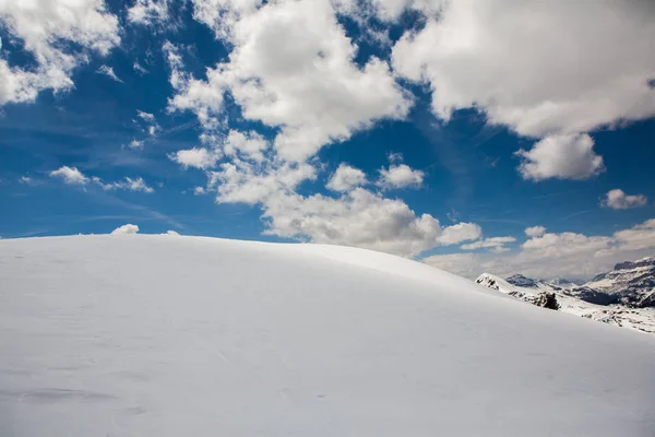 Beautiful winter landscape with snow in Alps. Dolomites. Panorama of snow mountain landscape with blue sky. Sunshine. Peaks. Rocks. Alps. Italy.