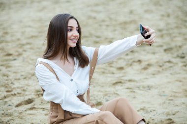 Kız dışarıda cep telefonuna mesaj atıyor. Telefonu olan kız. Telefonunda mutlu bir kadın metin sms mesajı Portresi.