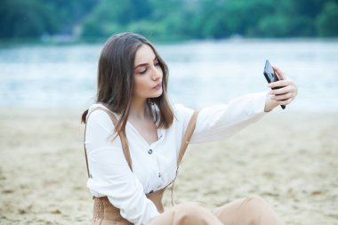 Kız dışarıda cep telefonuna mesaj atıyor. Telefonu olan kız. Telefonunda mutlu bir kadın metin sms mesajı Portresi.