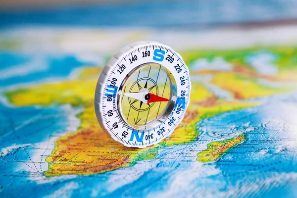 Compass on map. The magnetic compass is located on a geographic map. Satellites adventure. Travel concept.