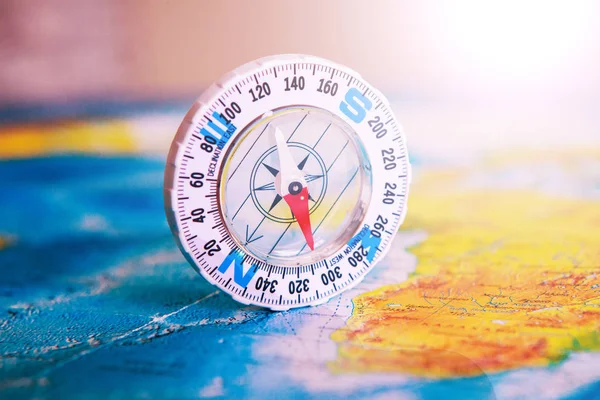 Compass on map. The magnetic compass is located on a geographic map. Satellites adventure. Travel concept.