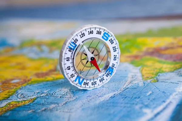 Compass on map. The magnetic compass is located on a geographic map. Satellites adventure. Travel concept.