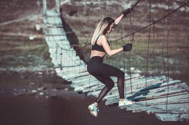 Çekici genç sportif kadın dışında çalışıyor. Çapraz uyum eğitimi. Kaslı kadın. Sportif mayo genç, zinde ve güzel kız. Spor, diyet, sağlık ve güzellik kavramı. Siyah spor iç çamaşırı genç kadın.