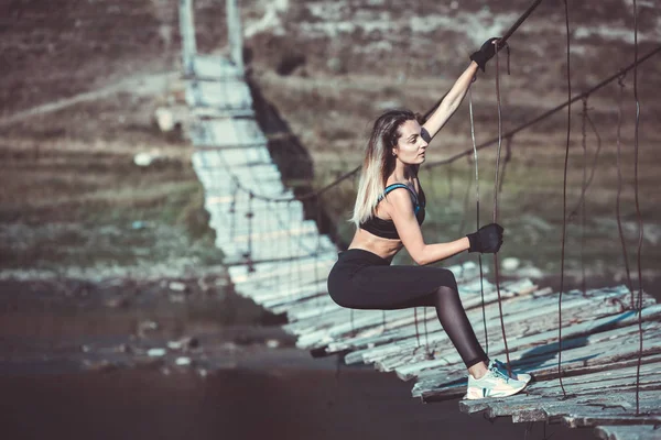 Attractive young sporty woman is working outside. Cross fit training. Muscular woman. Young, fit and beautiful girl in sporty swimsuit. Sport, diet, health and beauty concept. Young woman in black sport lingerie.