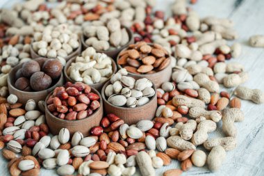 Arka plan badem, ceviz, fındık, fıstık, fındık, fıstık, fındık, fındık, fındık, fındık çeşitleri için çeşitli fındık koleksiyonu. Kurutulmuş meyveli kompozisyon sağlıklı yemek. Organik.