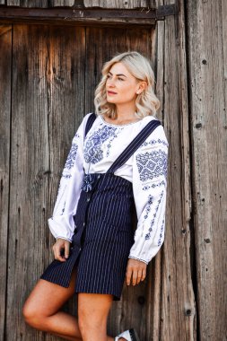 Geleneksel Romen halk kostümlü, nakışlı sarışın Avrupalı kız. Romen folkloru. 