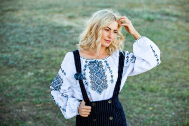 Geleneksel Romen halk kostümlü, nakışlı sarışın Avrupalı kız. Romen folkloru. 