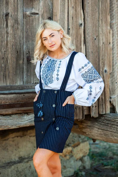 Blonde European girl in traditional Romanian folk costume with embroidery. Romanian folklore.