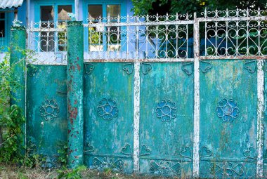 Kırsal mavi metalik kapı. Bir evin eski demir kapısı. Eski metal kapı arka planı. Metal dekorasyon.