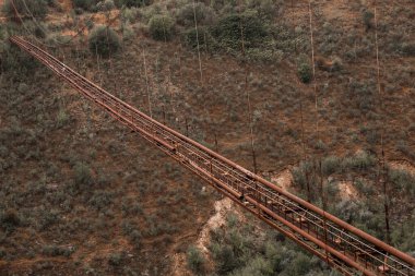 Eski demir işlevsiz asma köprü, kurumuş nehir manzarası üzerinde. Moldova 'daki eski yaya köprüsü. 