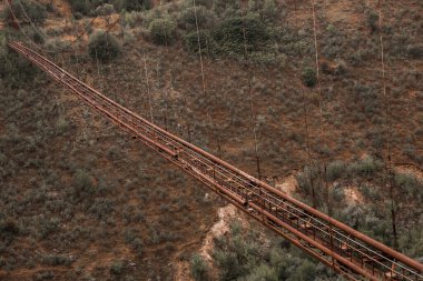 Eski demir işlevsiz asma köprü, kurumuş nehir manzarası üzerinde. Moldova 'daki eski yaya köprüsü. 