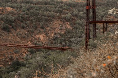 Eski demir işlevsiz asma köprü, kurumuş nehir manzarası üzerinde. Moldova 'daki eski yaya köprüsü. 