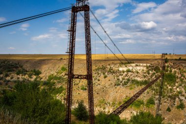 Eski demir işlevsiz asma köprü, kurumuş nehir manzarası üzerinde. Moldova 'daki eski yaya köprüsü. 