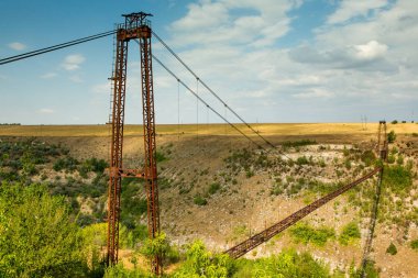 Eski demir işlevsiz asma köprü, kurumuş nehir manzarası üzerinde. Moldova 'daki eski yaya köprüsü. 